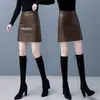 Falda de cuero versátil, falda de cuero mini PU negra para mujer otoño e invierno 2023, falda de línea A de cintura alta, falda corta ajustada, transfronterizo