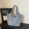 Bolso tote de textura de mezclilla desgastada azul claro con múltiples bolsillos, atuendo estilo coreano, bolso de hombro casual versátil para dama