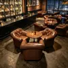 Cadeira de chefe europeia e americana neoclássica estilo hotel, sofá de lazer de encosto alto com design de puxador e conjunto de pufe, adequado para vilas, apresentando couro genuíno e um sofá estilo americano