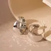 Pendientes de flor hueca cruzados de aguja de plata Europa y Estados Unidos pendientes de temperamento moda personalidad pendientes exagerados de alto nivel al por mayor mujeres