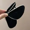 Pinza para el pelo de tiburón de moda de terciopelo con borde blanco, forma de mariposa negra flocada, Rojo de Año Nuevo 2025, Pasador de Otoño e Invierno para Mujer