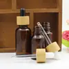 Frasco de vidro marrom para óleo essencial 5-100ml frasco para misturar essência de cuidados com a pele anel de bambu conta-gotas com cabeça de borracha frasco vazio para subembalagem