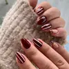 Set personalizado de 30 uñas postizas a rayas vintage color vino y blanco, con manicura francesa color vino tinto con detalles de estrellas doradas y uñas cortas en forma de almendra.