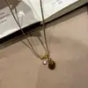 "Latido Ámbar" Colgante Círculo Piedra Ojo de Tigre Melard, Cadena Clavícula Negra Dorada de Alta Gama Estilo Chanel para Mujer