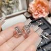 Pendientes de camelia estilo coreano personalizados creativos simples hip hop estrella masculina mismo estilo chapados en oro con incrustaciones de diamantes huecos nota musical