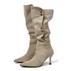 Sin embargo, estas son botas vaqueras de tacón alto de gamuza estilo retro para mujer, que llegan hasta la rodilla, con punta fina, tacón delgado y detalle de hebilla metálica.
