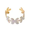 Un brazalete abierto para mujer, sencillo, de esmalte floral, versátil para el uso diario.