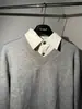 Suéter de punto gris claro de alta gama con cuello en V y diseño de dos piezas falsas, top de punto casual y sofisticado para hombre de invierno en estilo "old money"