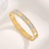 Nueva recomendación de éxito de ventas europea y americana: Pulsera de acero de titanio dorado para mujer, estilo INS, lujo ligero, versátil, con incrustaciones de diamantes y detalles de concha blanca, al por mayor