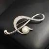 Broche Clásico Elegante de Gama Alta con Forma de Nota Musical, Chapado en Oro, con un Diseño Sencillo y Estilizado, Presenta Líneas de Perlas de Imitación, Adecuado Tanto para Hombres como para Mujeres