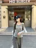 Foto real de outono e inverno de 2026 estilo coreano gola redonda design de botões cor sólida elegante versátil manga longa camiseta top para mulheres 19578