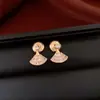 Pendientes de borla con flor de trébol de circonita vintage con un toque de alta gama, pendientes versátiles y de moda al por mayor