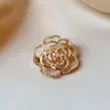 Broche pequeño y elegante en forma de camelia con intrincados detalles calados, un accesorio lujoso y sofisticado para mujer, perfecto para combinar con trajes y prendas de abrigo