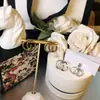 Precio de fábrica al por mayor comercio exterior joyería de cobre elegante retro hacer viejo pendientes Doble G simples estilo INS atmosféricos pendientes de botón con letra para mujer