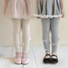 Venta al por mayor transfronteriza leggings nuevos para niñas primavera y otoño 2026 para usar como prenda exterior, pantalones de algodón a rayas verticales para niños con múltiples lazos, longitud recortada