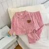 Conjunto de loungewear infantil moderno para primavera, verão e outono, estilo coreano, com um fofo design de urso de desenho animado, mangas compridas e padrão xadrez, perfeito para pijamas de bebê