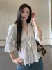 Blusa blanca otoñal, elegante y estilosa, con corte holgado, diseño versátil y un escote en V suave de inspiración francesa y mangas tres cuartos.