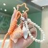 Colgante de concha curativa de moda, pulsera tejida, llavero de cadena de perlas, charm de bolso girly creativo, venta al por mayor