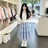 Conjunto versátil y moderno de dos piezas para niños mayores, que incluye una camisa tipo polo de retazos a cuadros de moda y una falda, perfecto para primavera y otoño