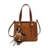Moderna colección de otoño 2026 para mujer, estilo caricatura minimalista, bolso de hombro, bolso de mano y bolso cruzado de alta gama y único para el trabajo.