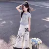 Conjunto de dos piezas a la moda estilo universitario para niños de mediana edad y mayores: camiseta polo de manga corta a rayas y patchwork y pantalones casuales anchos con ribete de encaje