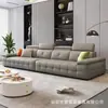 Sofá italiano minimalista de cuero negro con módulos de rejilla, reposacabezas ajustables, profundidad de asiento profunda, adecuado para varias personas en la sala de estar del hogar.