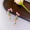 Pendientes largos con borlas y orquídeas frescas. Pendientes de lazo estilo pastoral con cuentas.
