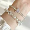 Pulsera Francesa Dulce Fresca de Perlas para Mujer con Lazo de Pedrería Mariposa Morada Trébol de Cuatro Hojas Colgante Cadena de Mano Nicho Aura de Lujo Ligero