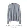Suéter de cashmere com estilo clássico e vintage, apresentando padrão trançado, gola redonda e um design de tricô solto e versátil.