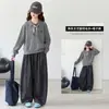 Atuendo otoñal elegante y moderno para niñas: un suéter de punto y una camisa polo de estilo preppy, combinados con pantalones de cuadros, perfectos para primavera y otoño