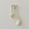 Meias femininas estilo coreano, nova coleção outono e inverno, com etiqueta de tecido, borda franzida de agulha dupla, meias de cano médio para crianças maiores, feitas de algodão penteado