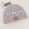 Gorro de punto de estilo coreano inspirado en la dopamina con un lazo, diseñado para mujeres, que proporciona calor y protección para los oídos en otoño e invierno, y favorece el rostro; un sombrero pequeño y elegante para estudiantes