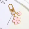 Moda simples de best-seller da Amazon transfronteiriça, material de liga, tinta em pó de pérola, pingente de flor de cerejeira para bolsas e malas