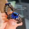 Anillo de corindón rojo tesoro, estilo moderno y elegante, chapado en oro negro, estilo vintage, con alas de ángel y cristal azul puntiagudo para mujer.