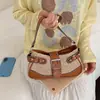 Bolso de hombro cruzado de nicho estilo nuevo tejido a mano con paja y hebilla metálica estilo motociclista de moda para el día a día de mujer, resistente