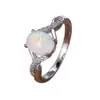 Anillo ovalado de ópalo más vendido transfronterizo, con un diseño de banda retorcida y detalles de ópalo engastados con diamantes.