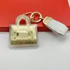 Capa exterior con marca famosa dorada, colgante de llavero de alta gama transfronterizo, regalo para la industria de la belleza, regalo para impulsar el tráfico en transmisiones en vivo, recuerdo para clientes