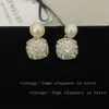 Pendientes de botón de estilo de lujo ligero de moda con baño de oro, diamantes completos de imitación y perlas para mujer, brillantes y elegantes para invierno y Año Nuevo