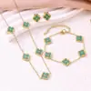 Conjunto de tres piezas de la suerte estilo europeo y americano: conjunto vintage de collar, aretes y pulsera de trébol de cuatro hojas en negro y dorado. Accesorios versátiles para el trayecto al trabajo al por mayor