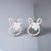 Pendientes de botón de aleación con cabeza de conejo de dibujos animados dulces y lindos estilo coreano con cuentas de arroz, pendientes simples, frescos y versátiles
