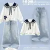 Roupa de outono para meninas: um conjunto de duas peças apresentando calças pantalona, um moletom moderno estilo preppy e calças jeans casuais