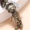 Llavero de cuero de vaca tejido retro personalizado para joyería transfronteriza, llavero de robot de dibujos animados creativo con manos y pies móviles