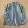 Coleção Primavera 2026 Camisa Jeans Manga Longa Bordada com Bolso Vintage Desgastada Top Solto Casual Versátil