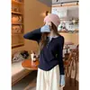 Camiseta de manga larga con diseño de color contrastante para mujer, estilo coreano, con cuello semibierto cepillado y botones en el hombro derecho, para otoño e invierno.