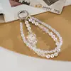 Nuevo colgante de teléfono de doble cadena con un toque de alta gama, cuentas luminosas de flor de cerezo, correa de muñeca para teléfono, charm para bolso, pequeño regalo para mujeres