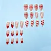 Arte de uñas con temática navideña: Diseños de copos de nieve en tonos nude, rojo y blanco, perfectos para crear un ambiente festivo. Opciones mayoristas disponibles para ventas transfronterizas. Incluye gorro de Navidad y lazo para regalo