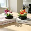 Flores artificiais de jasmim dourado em vaso de pedras para decoração de varanda de casa, flores falsas em um pequeno ornamento de bonsai plano