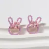 Pendientes de botón de aleación con cabeza de conejo de dibujos animados dulces y lindos estilo coreano con cuentas de arroz, pendientes simples, frescos y versátiles
