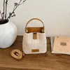 Bolso de paja tipo cubo nuevo estilo vacación de verano en la playa 2026, con un fresco diseño de patchwork en colores contrastantes y una textura tejida simple, un bolso para mujer
