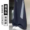 Calça esportiva feminina azul marinho com três listras, perna curva, cintura alta, caimento solto, modeladora, fresca e estilosa, adequada para fitness e uso casual, calça pantalona para o outono